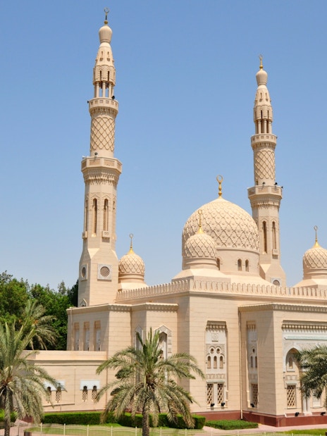 Jumeirah Mosque with twin minarets and palm trees in Dubai.