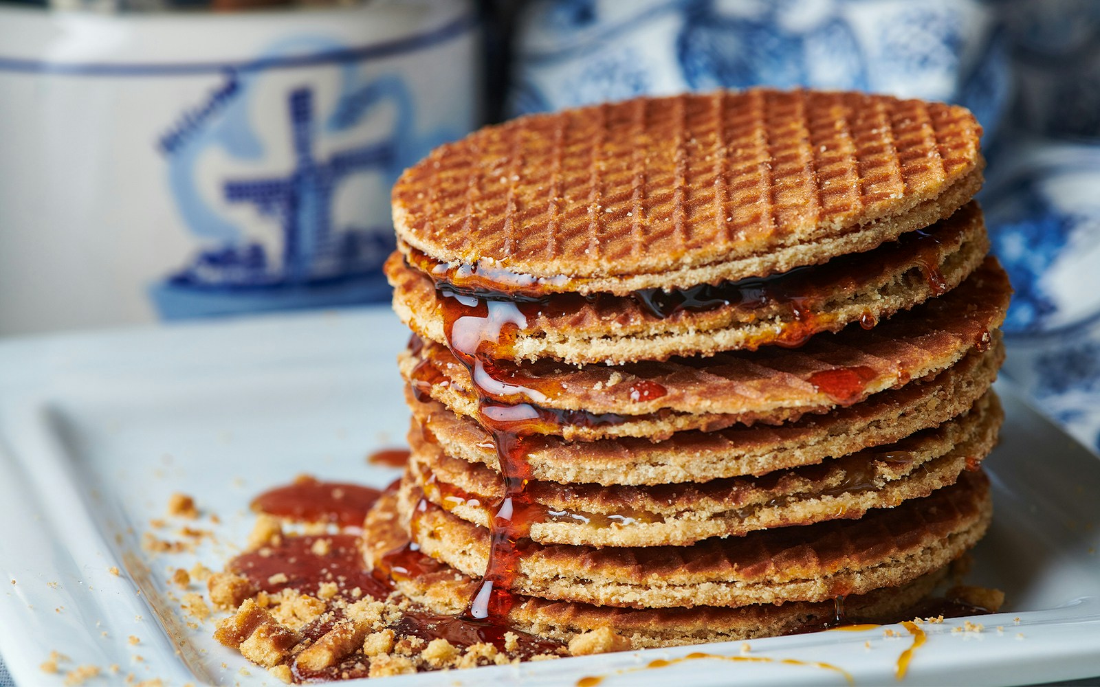 Stack of Dutch stroopwafels with syrup oozing on a plate.