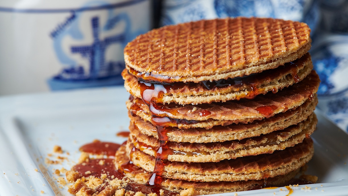 Stack of Dutch stroopwafels with syrup oozing on a plate.