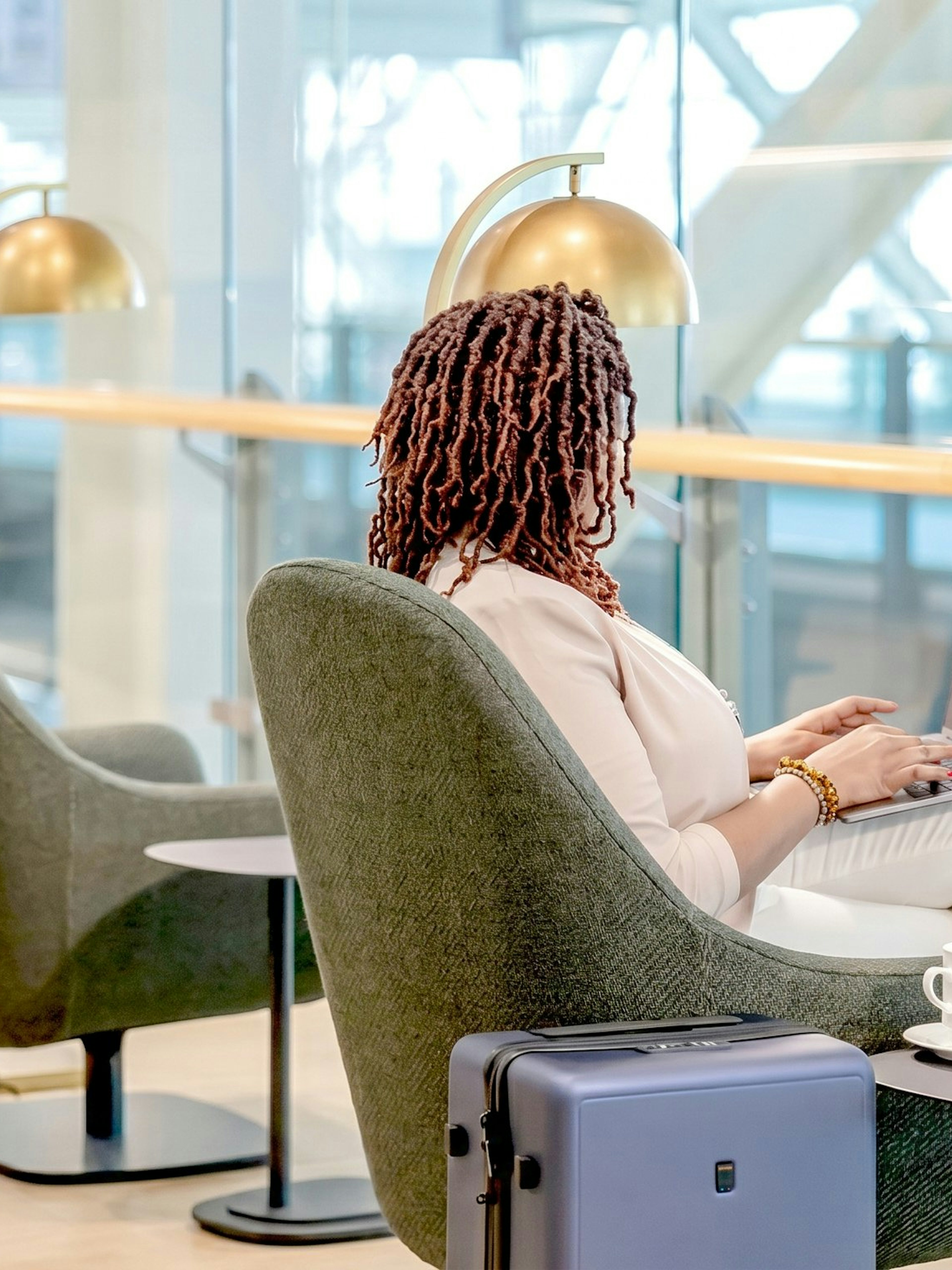 Person working on a laptop in Plaza Premium Lounge, Vancouver International Airport.