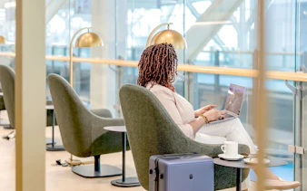 Person working on a laptop in Plaza Premium Lounge, Vancouver International Airport.
