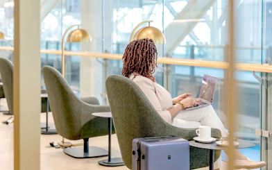 Person working on a laptop in Plaza Premium Lounge, Vancouver International Airport.