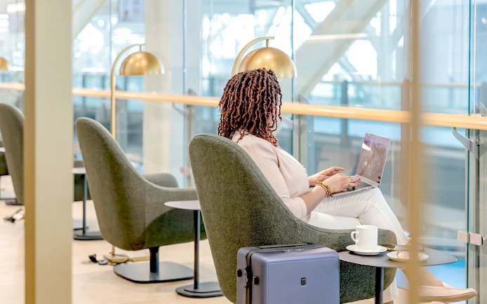 Person working on a laptop in Plaza Premium Lounge, Vancouver International Airport.