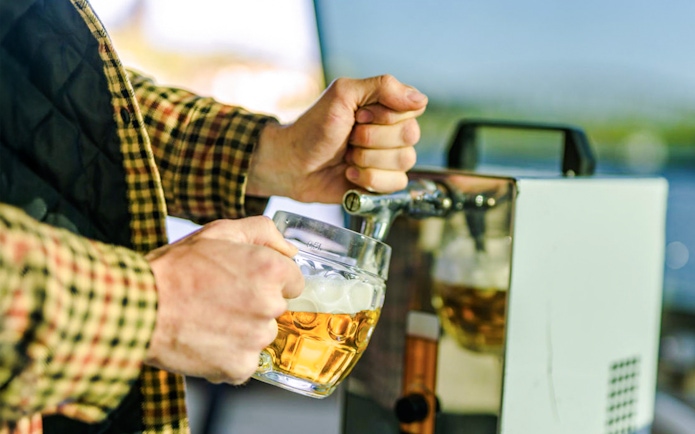 Pouring beer from a tap on a Prague beer boat tour.