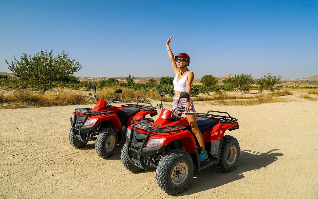 Person on ATV in Cappadocia desert landscape, part of Red Tour experience.