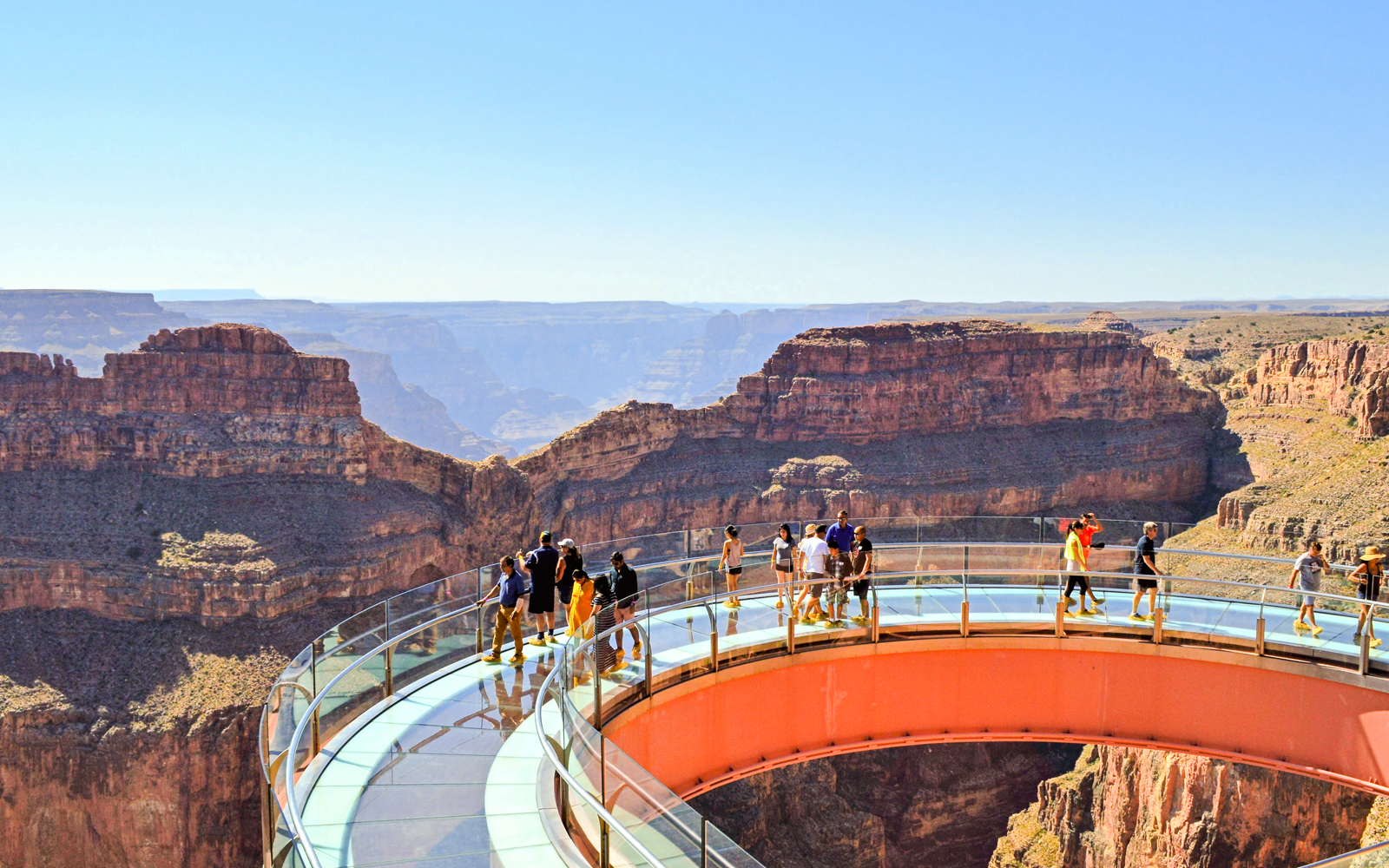 Grand Canyon Skywalk with visitors on glass bridge overlooking canyon.
