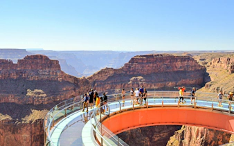 Grand Canyon Skywalk with visitors on glass bridge overlooking canyon.