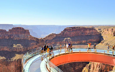Grand Canyon Skywalk with visitors on glass bridge overlooking canyon.