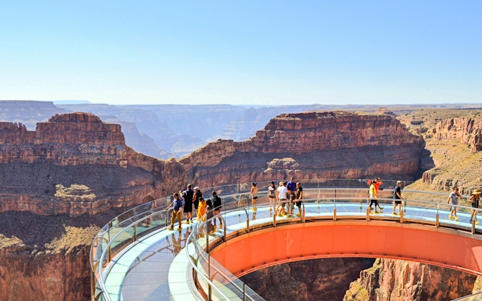 Grand Canyon Skywalk with visitors on glass bridge overlooking canyon.