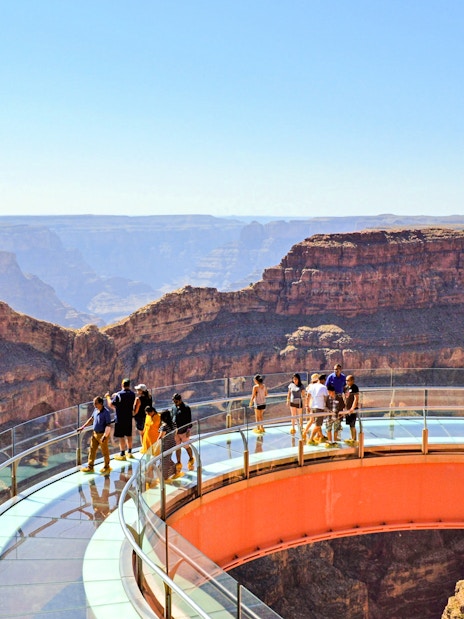 Grand Canyon Skywalk with visitors on glass bridge overlooking canyon.