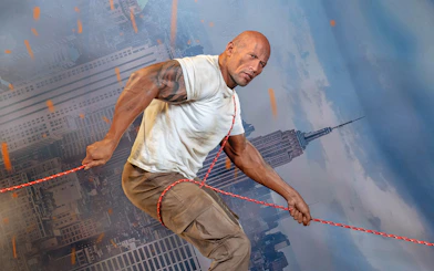 Wax figure of Dwayne Johnson holding a rope at Madame Tussauds Orlando.