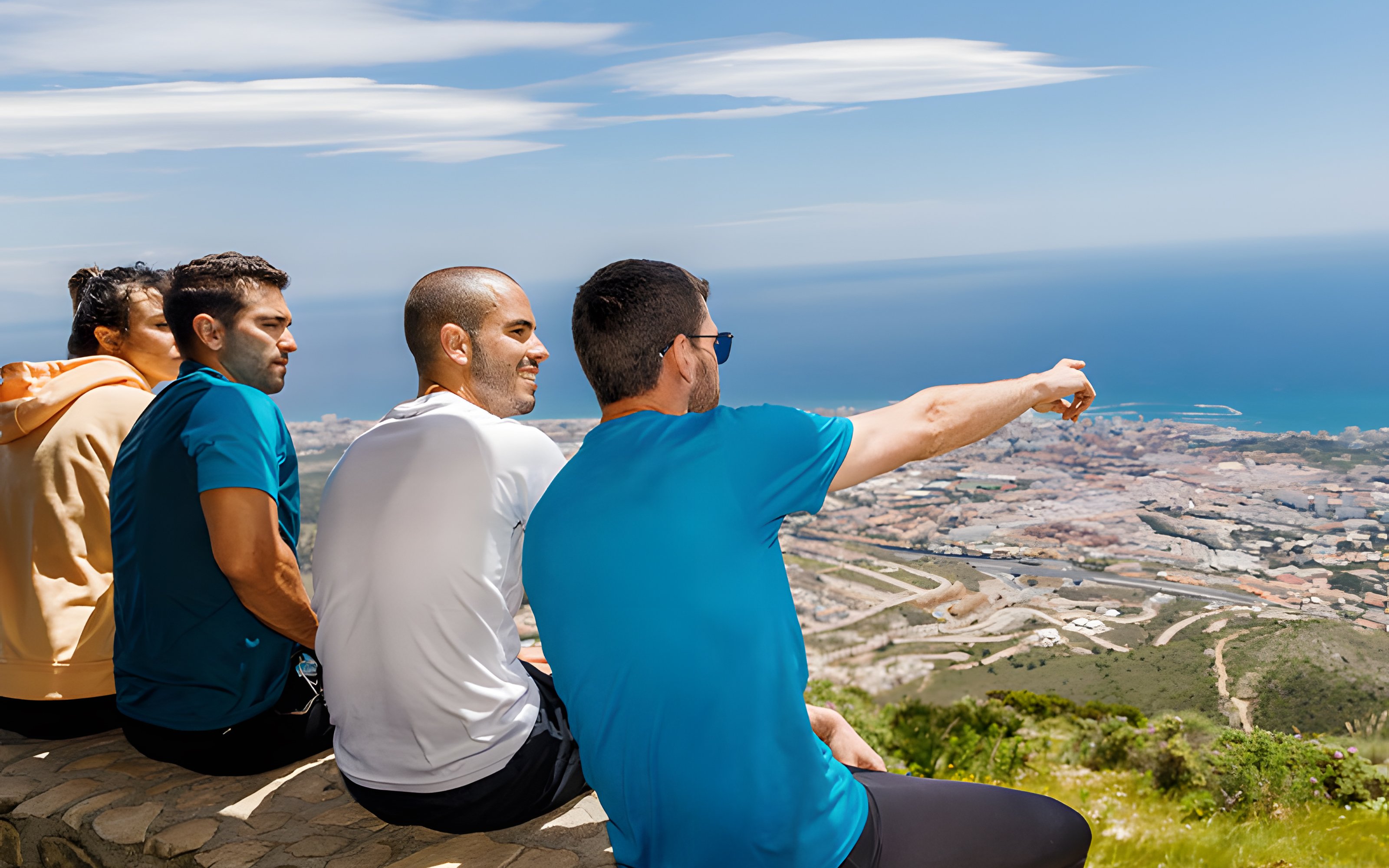 Group enjoying the view from Mount Calamorro summit, overlooking Benalmádena and the sea, Spain.