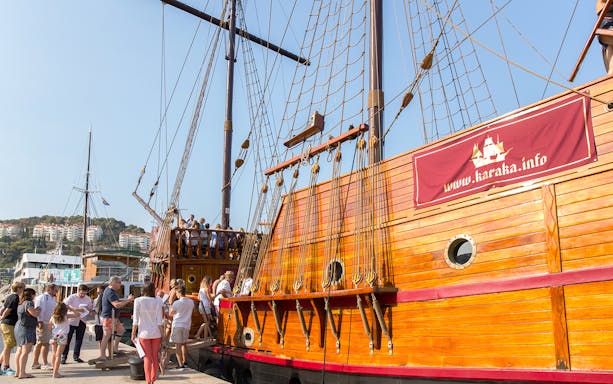 Tourists boarding a wooden ship for a guided Elaphite Islands cruise.