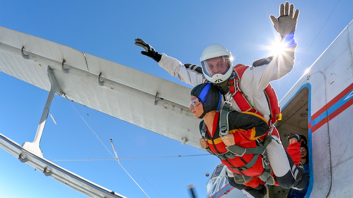 Tandem skydivers jumping from a plane over Abu Dhabi.