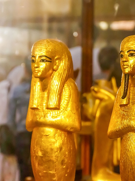 Golden statues of ancient Egyptian figures at the Egyptian Museum of Antiquities.
