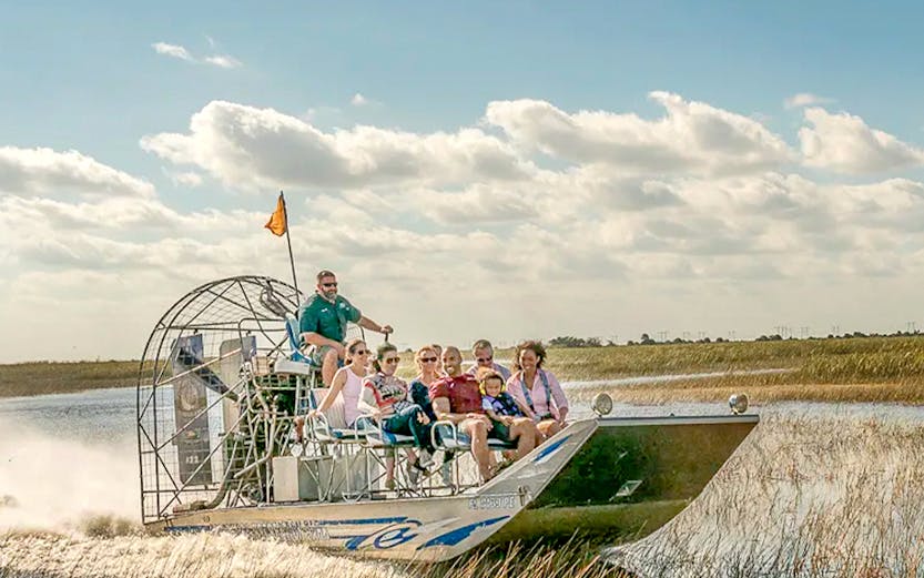 Airboat tour through the Florida Everglades with passengers enjoying the ride.