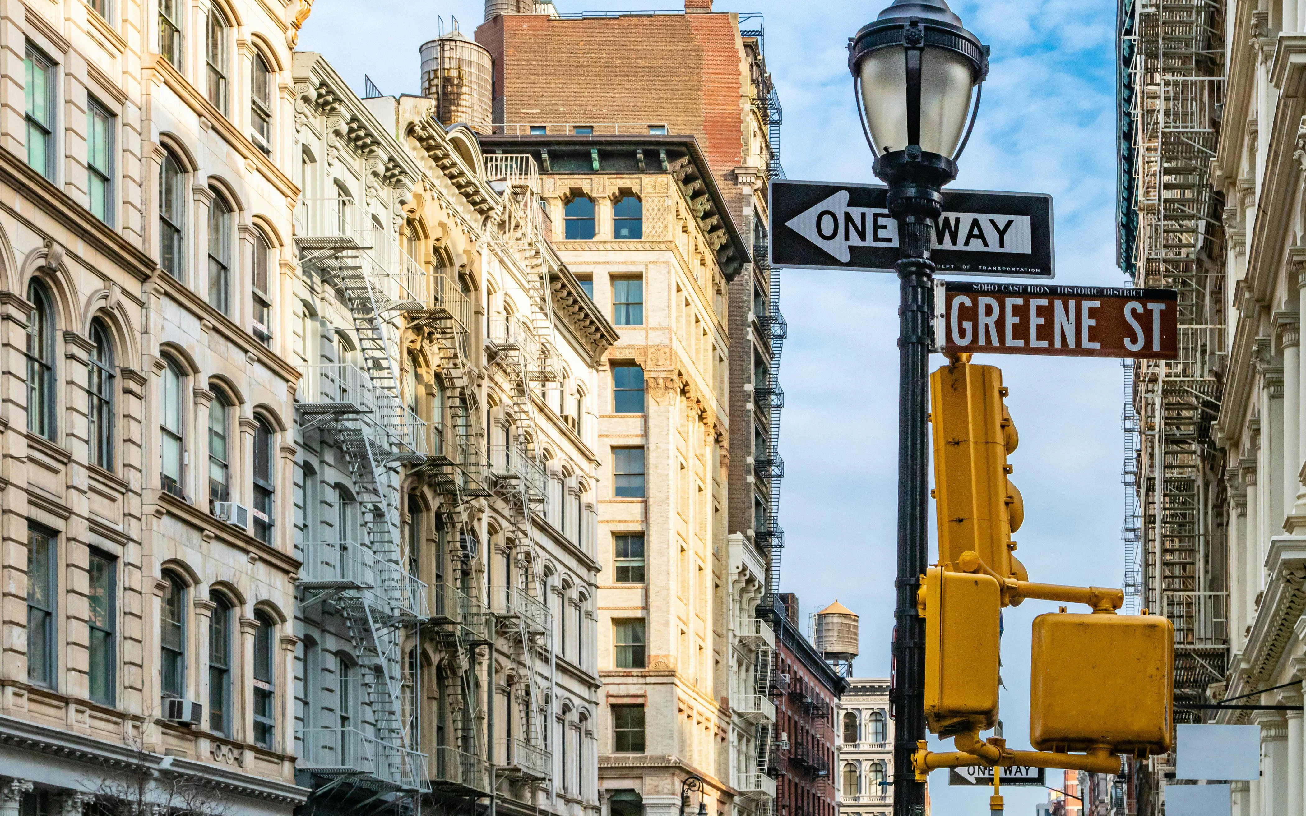 Greene Street sign and historic buildings at a SoHo intersection, New York City.