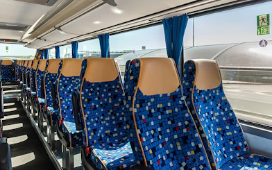 Autostradale Airport Transfer bus seating arrangement with blue patterned seats.