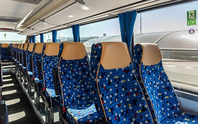 Autostradale Airport Transfer bus seating arrangement with blue patterned seats.