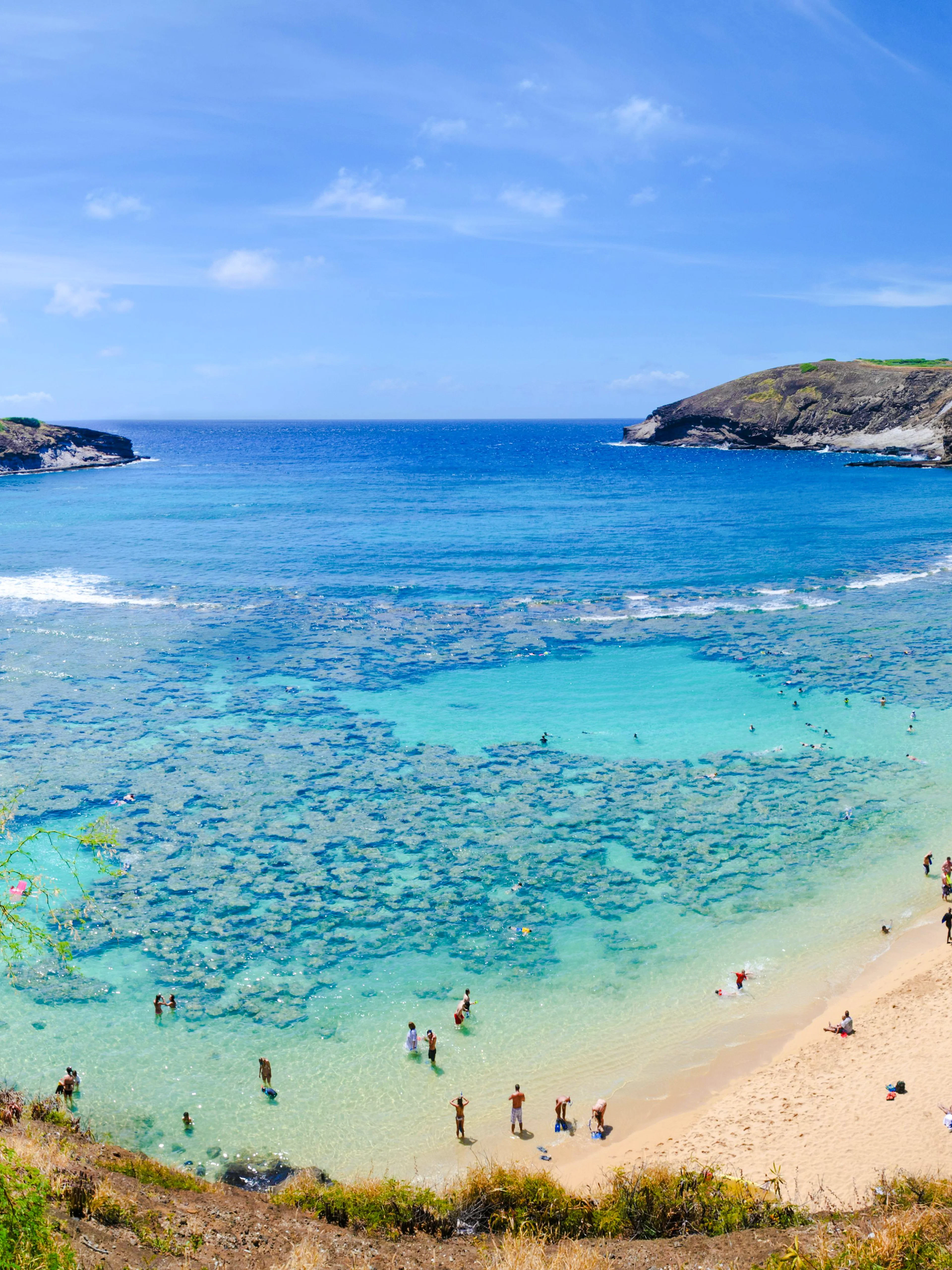 Hanauma Bay beach with swimmers and coral reef, Oahu, Hawaii.