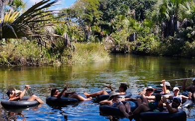 Tubing group floating on a river in Cardosa, surrounded by lush greenery, Barreirinhas.
