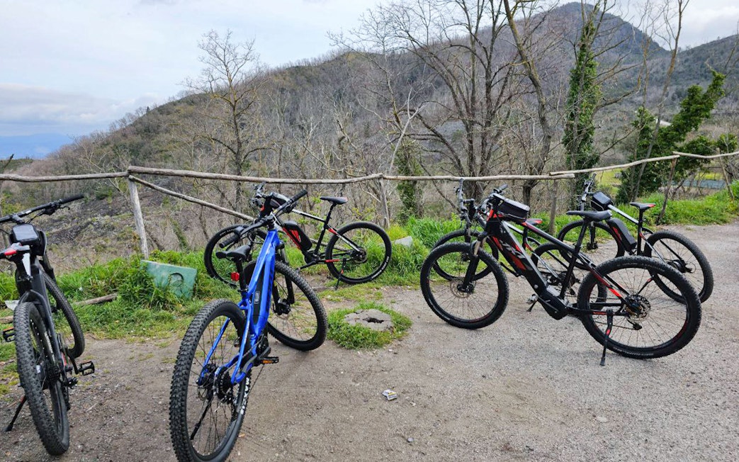 E-bikes parked on a trail with Mount Vesuvius in the background during a guided tour from Sorrento.