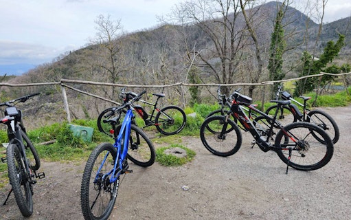 E-bikes parked on a trail with Mount Vesuvius in the background during a guided tour from Sorrento.