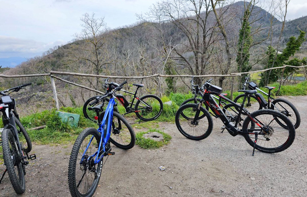 E-bikes parked on a trail with Mount Vesuvius in the background during a guided tour from Sorrento.