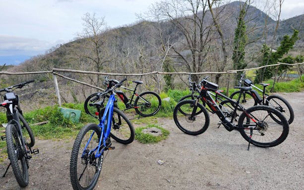 E-bikes parked on a trail with Mount Vesuvius in the background during a guided tour from Sorrento.
