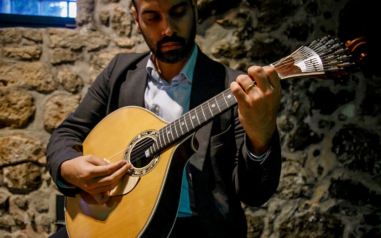 Performer playing guitar at Live Fado Show, Fonseca Port Wine Cellars.