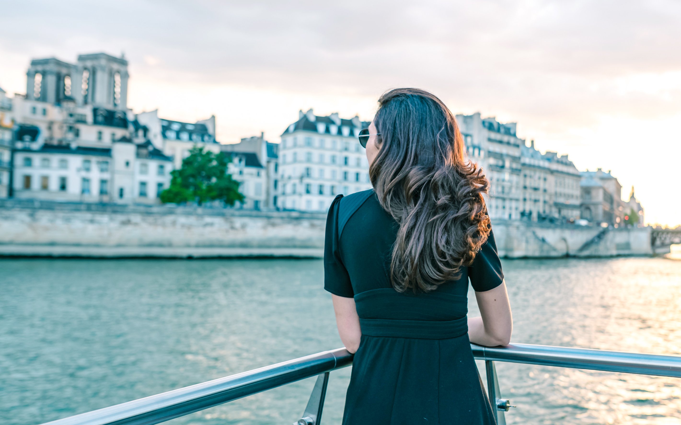 Woman enjoying Seine River Cruise at sunset in Paris.