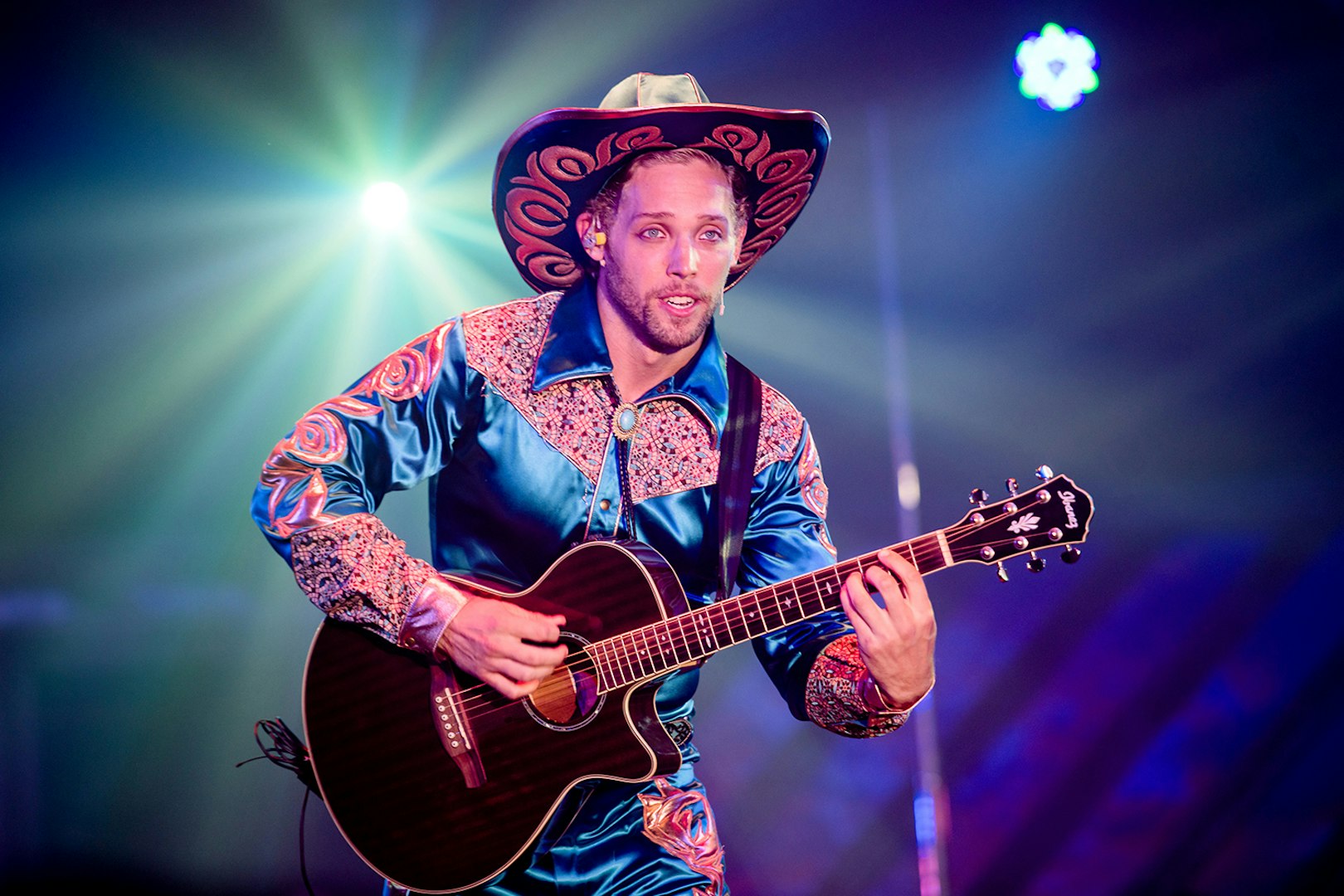 Performer playing guitar at Atomic Saloon Show.