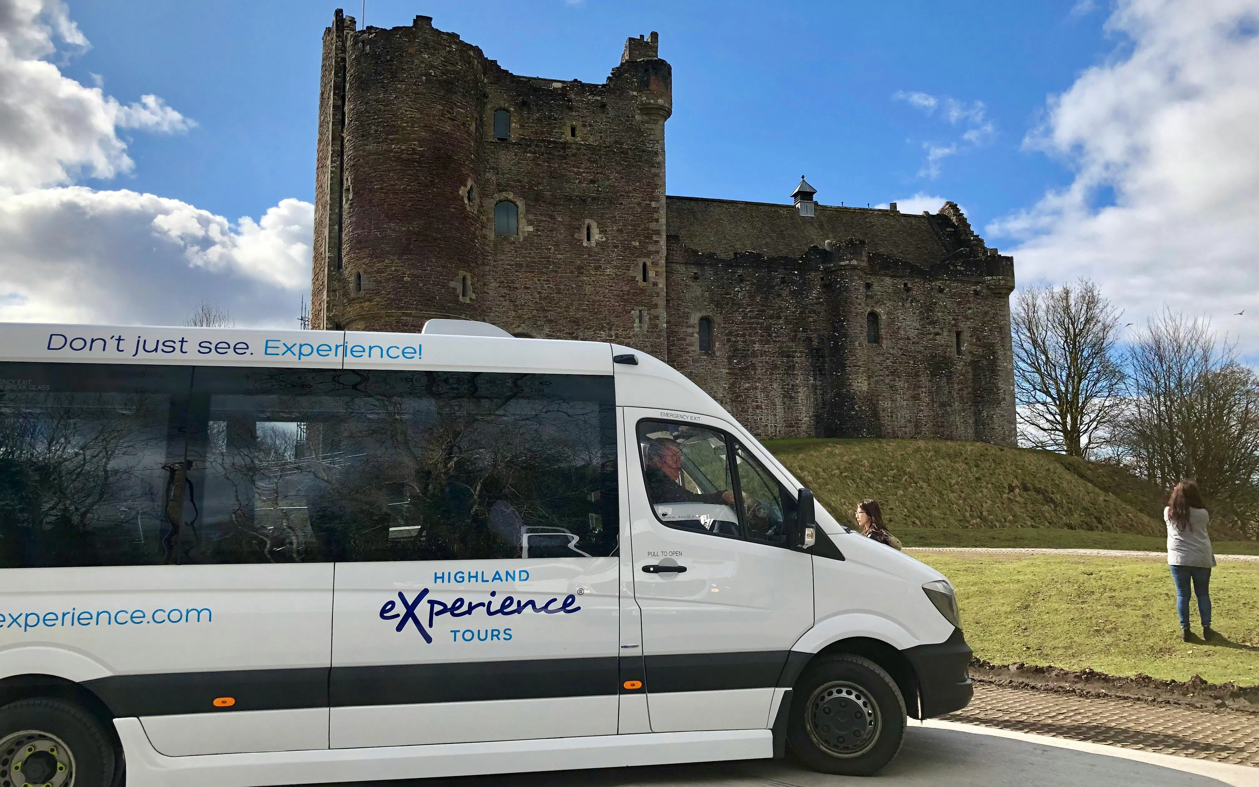 Tour bus at Doune Castle, Scotland, part of the Outlander Experience 1-day Tour from Edinburgh.
