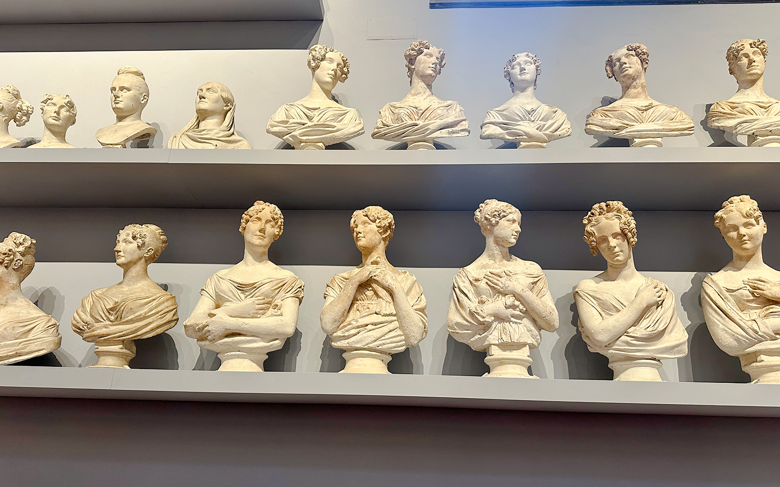 Bust sculptures displayed on shelves in Accademia Gallery, Florence.