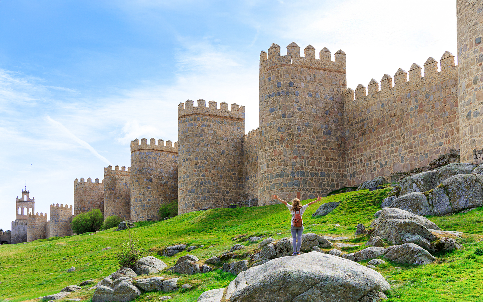 Tourist admiring the medieval city walls of Ávila, Spain.