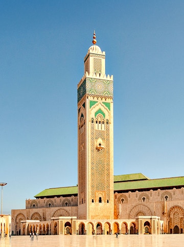 Hassan II Mosque minaret in Casablanca, Morocco, under a clear blue sky.
