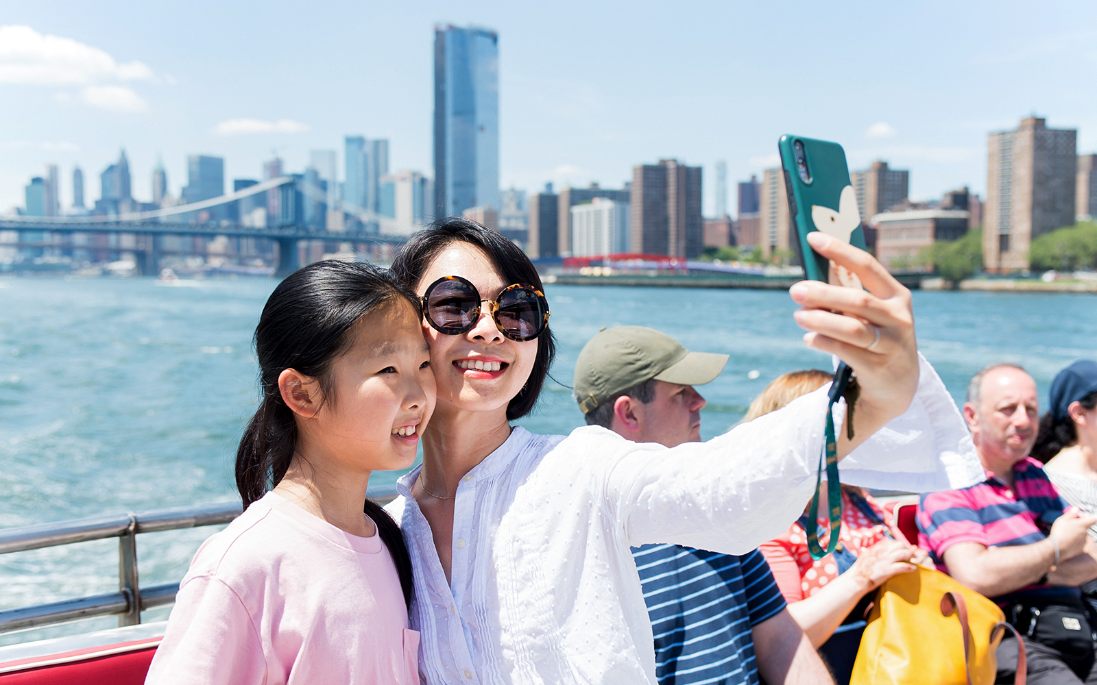 Tourists enjoying the NYC Brunch Cruise with a view of the New York skyline in the background