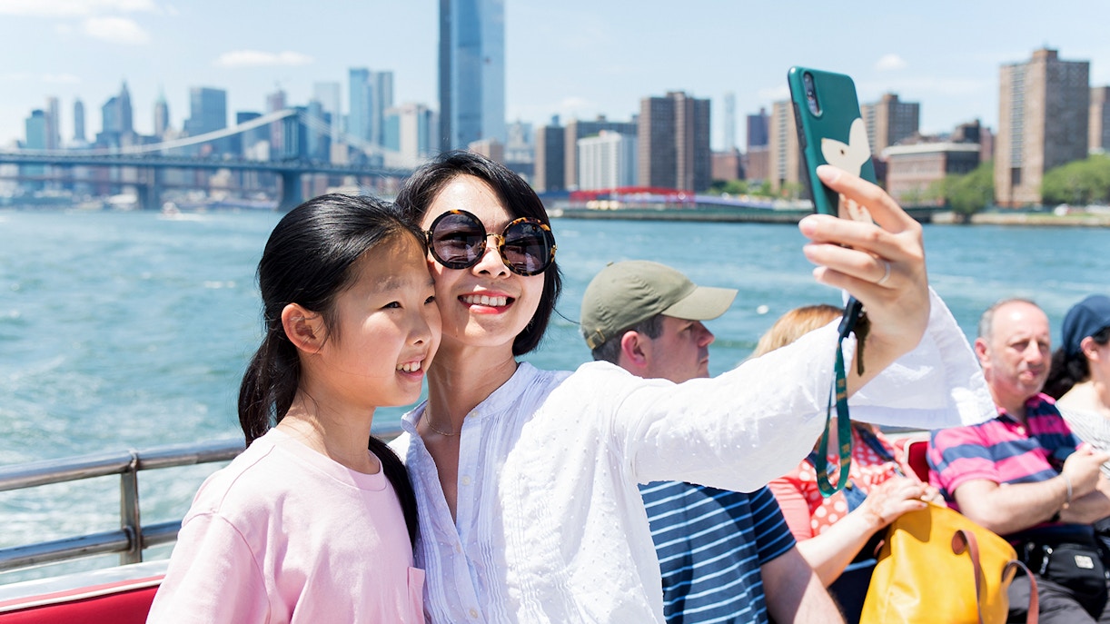 Tourists enjoying the NYC Brunch Cruise with a view of the New York skyline in the background