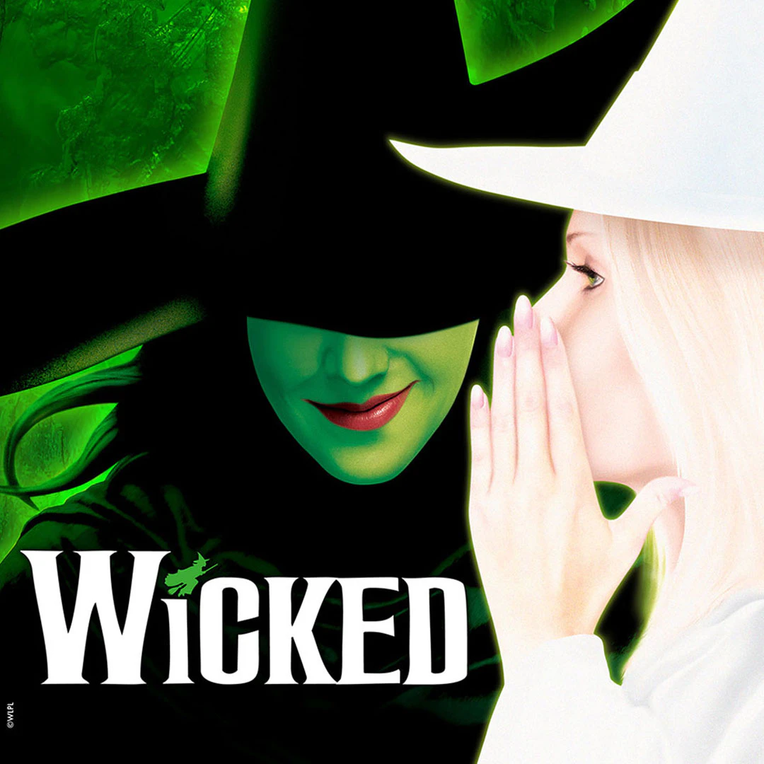 To figurer fra musicalen Wicked, den ene med en sort hat og den anden, der hvisker.
