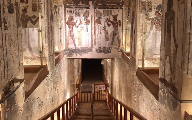 Entrance to Luxor's ancient tomb with detailed wall hieroglyphs and paintings.