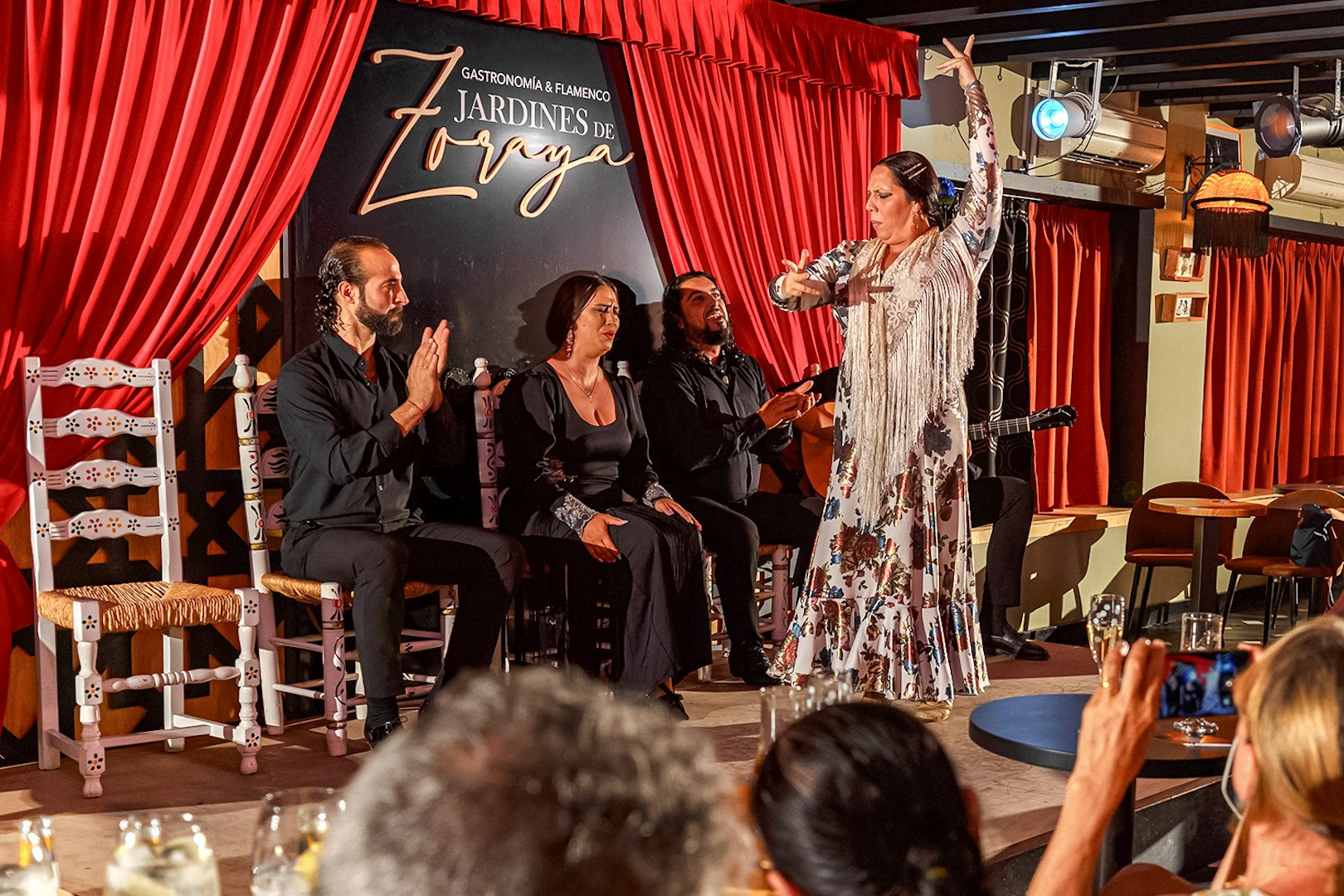 Flamenco dancer performing at Tablao Jardines de Zoraya with musicians in Granada.