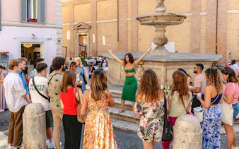 Tourists gathered around a guide at a fountain in Rome's Monti neighborhood.
