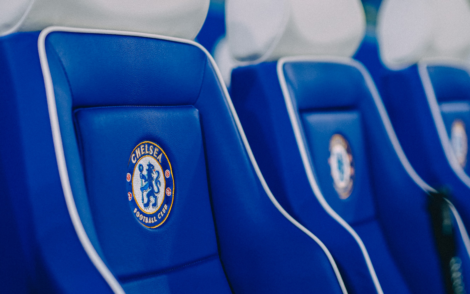 Chelsea FC stadium seats with team logo.