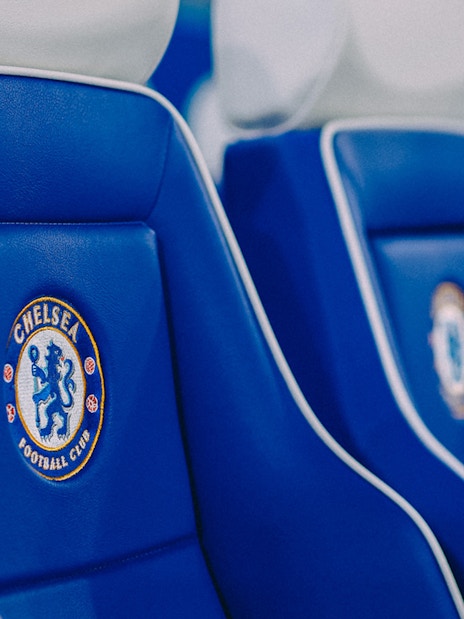 Chelsea FC stadium seats with team logo.