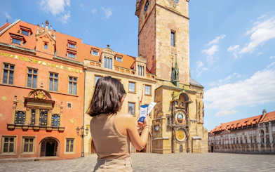 Visitor using audio guide at Prague Astronomical Clock in Old Town Square.
