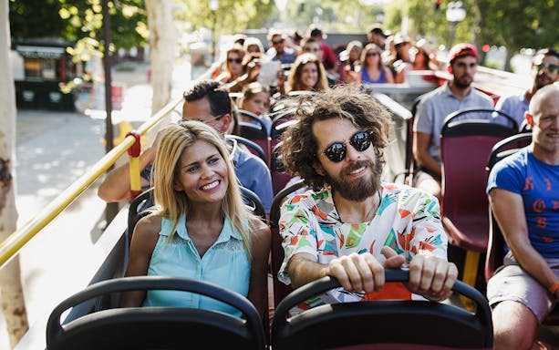 Tourists enjoying a sunny day on a Kiel hop-on hop-off bus tour.