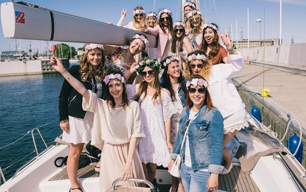 Group enjoying a private boat tour in Gdansk and Sopot, wearing floral headbands.