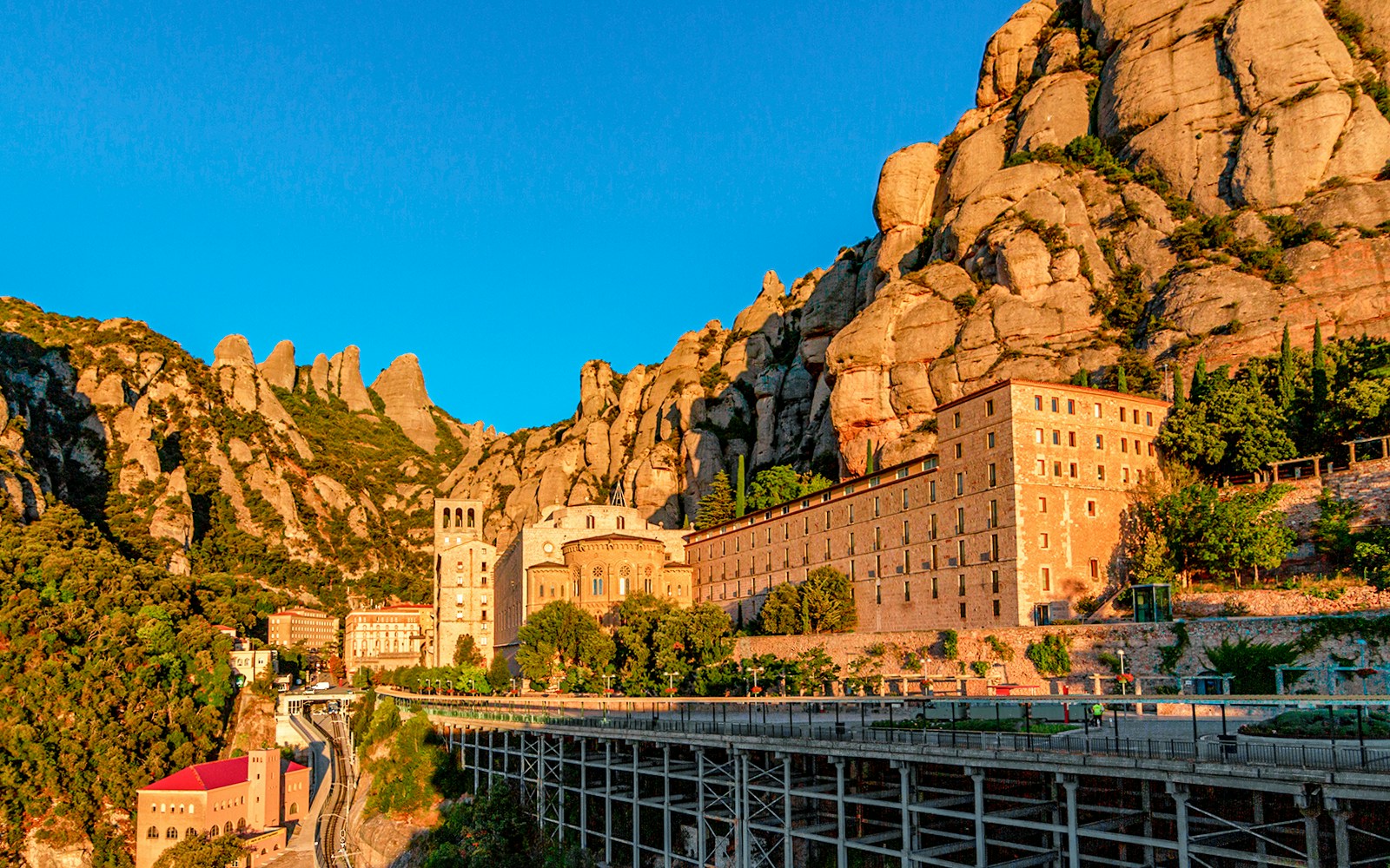 Montserrat monastery with mountain backdrop at sunset.