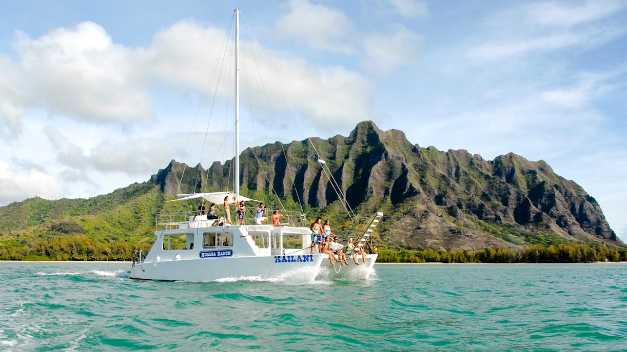 Catamaran sailing near Kualoa Ranch mountains, Ocean Voyage Adventure, Hawaii.