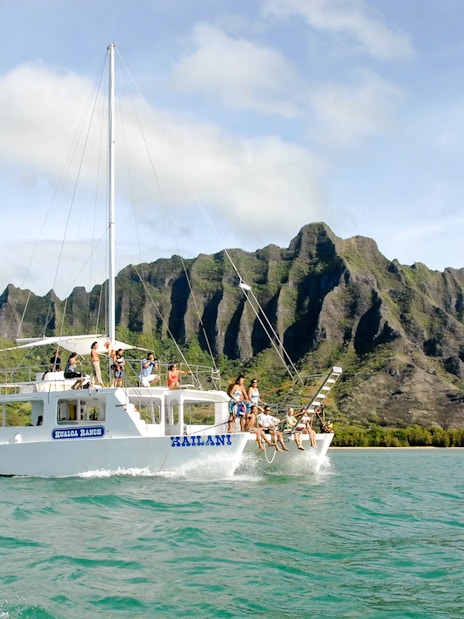 Catamaran sailing near Kualoa Ranch mountains, Ocean Voyage Adventure, Hawaii.
